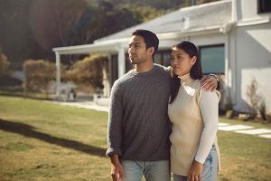 Couple standing in front of house concerned